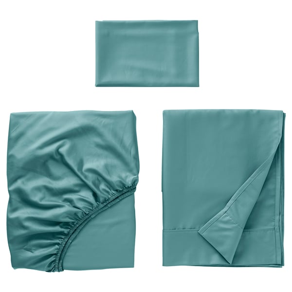 Three pieces of luxurious teal bedding: sheet, fitted sheet, pillowcase. Made from smooth cotton and lyocell blend, sateen-woven.