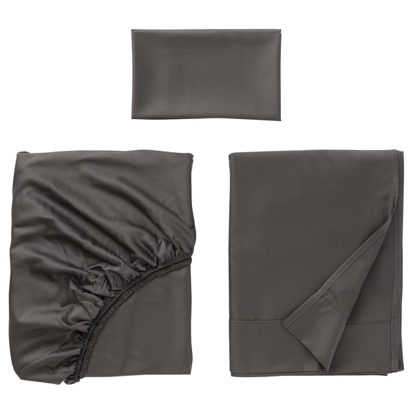 Three grey fabric items displayed: folded pillowcase, gathered sheet, flat-folded bedsheet, soft, smooth texture.