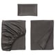 Three grey fabric items displayed: folded pillowcase, gathered sheet, flat-folded bedsheet, soft, smooth texture.