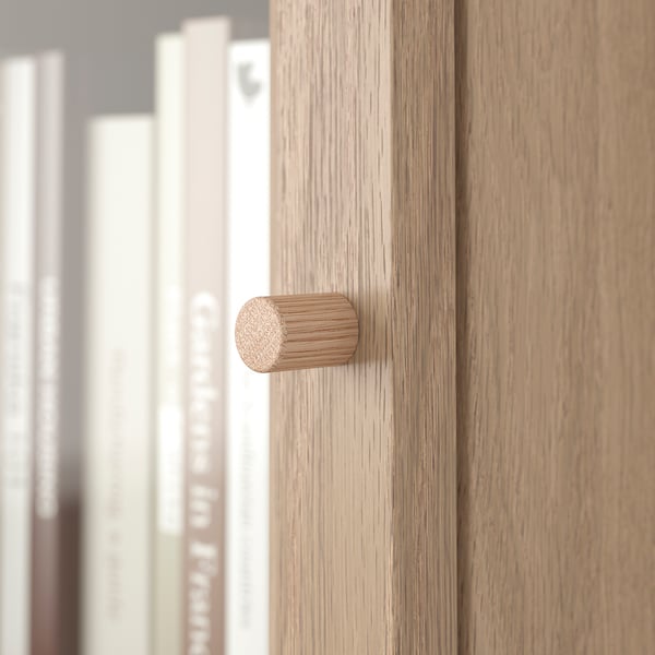 Wooden drawer with cylindrical handle, part of modern furniture set.