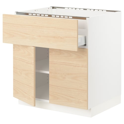 Wooden kitchen cabinet with open drawer, light ash finish.