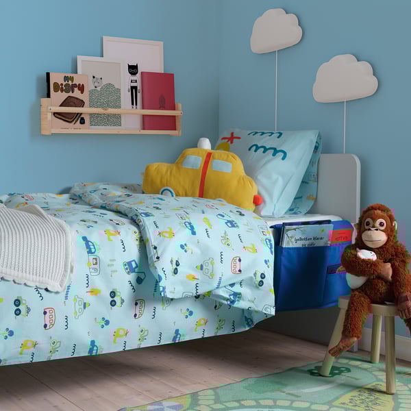 Childs blue bedroom with plane pillow bed, book pocket, cat shelf, & monkey on stool.