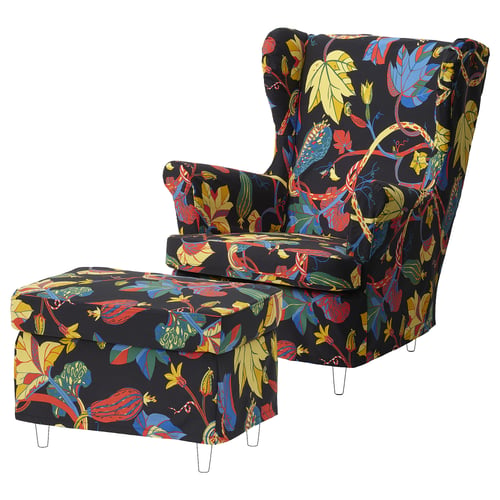 STRANDMON wing chair & footstool: black, floral print, high back, curved armrests, colourful leaves design.