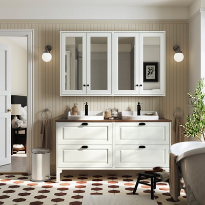 Minimalist double sink vanity with white base, wood counters, black handles, mirrors, and dark floor.