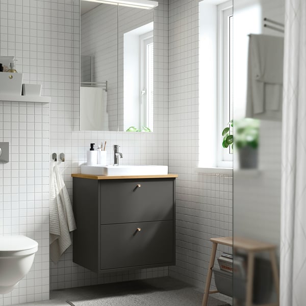 Modern bathroom with HAVBÄCK vanity, mirror, plant.