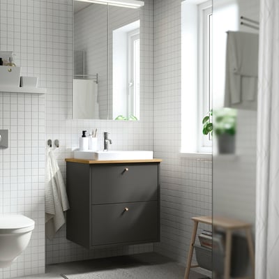 Modern bathroom with HAVBÄCK vanity, mirror, plant.