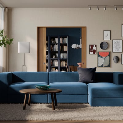 Modern living room: blue sofa, wooden table, lamp, art on bright walls.