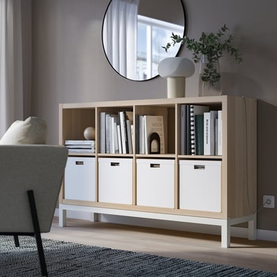 White KALLAX shelving with books, decor, plants, and mirror.