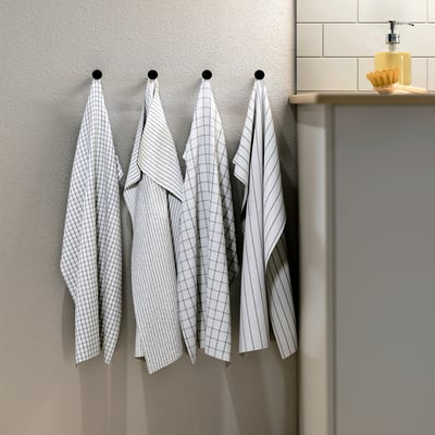 Four grey towels with square and stripe patterns hang neatly, two with checks, two with stripes, all in white and grey cotton.