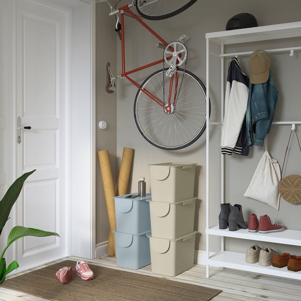 Organised entryway with light blue/beige TRÖSKNING bins, mounted bike & storage.