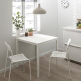 Malý bílý stůl a židle ADDE, moderní, minimalistický design. Obklopen kuchyňským dekorem, vhodný pro malé prostory.
