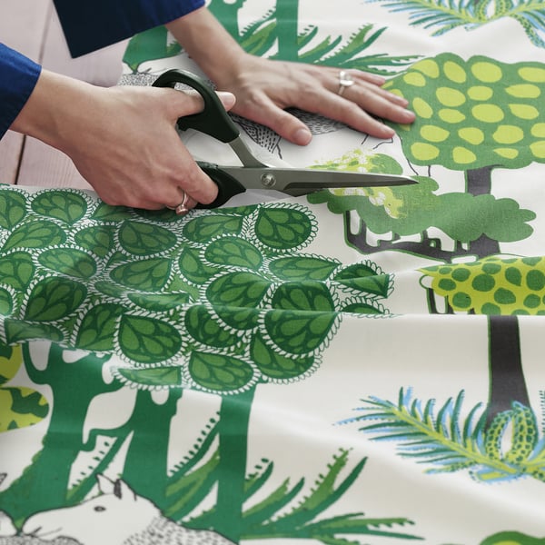 Řezání zelené listové látky z kolekce ikeas ÄLGÖRT pro šití projektů.