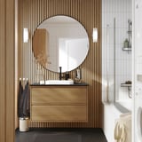 Moderní koupelna s dubovým umyvadlem ÄNGSJÖN, velkým zrcadlem, skříňkou a vanou se zlatým příslušenstvím.