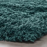 Měkká, plyšová modrozelená koupelnová předložka. Textura s hlubokým vlasem, recyklované materiály.