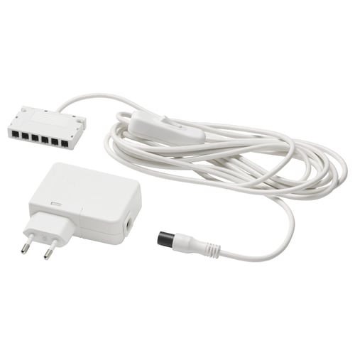 Bílá sada napájecího adaptéru ANSLUTA obsahující ovladač, kabel a zástrčku, určená k ovládání až šesti světelných zdrojů jedním vypínačem.