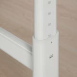 Nastavitelná bílá tyč na stůl s výškovými značkami; kovová svorka. Čistý, praktický design pro snadné použití.