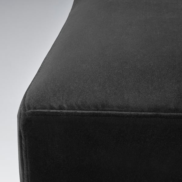 Sametová židle zblízka, detail měkké černé textury.