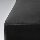 Sametová židle zblízka, detail měkké černé textury.