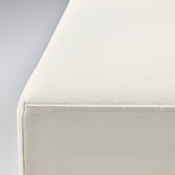 Detailní záběr na bílé, polstrované křeslo, které předvádí své čisté linie a pohodlnou látku.