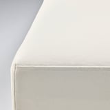 Detailní záběr na bílé, polstrované křeslo, které předvádí své čisté linie a pohodlnou látku.