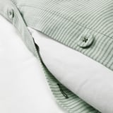 Detail přikrývky s pruhovaným vzorem příze a ozdobným knoflíkem.