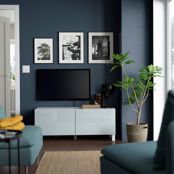 Moderní obývací pokoj s TV stolkem BESTÅ, TV a dekorací. Modré stěny, modrozelený nábytek.