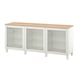 Bílý příborník IKEA BESTÅ se třemi skleněnými dvířky a dřevěnou deskou. Skříňka má moderní design s nastavitelnými policemi pro ukládání.