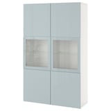 Světle modrý úložný díl BESTÅ se skleněnými dvířky. Má obdélníkový tvar a elegantní design, který kombinuje úložný prostor a vystavení.
