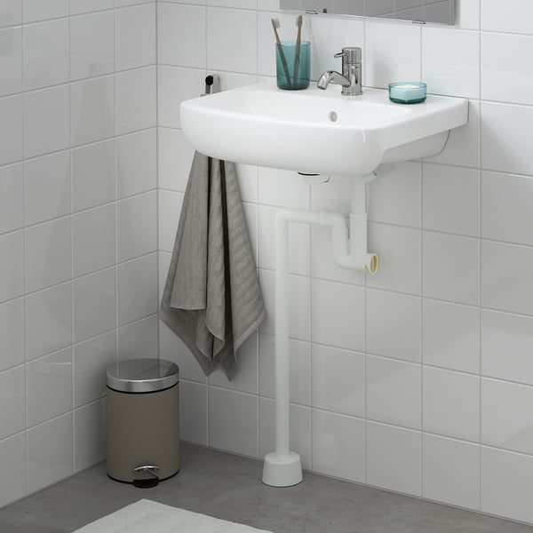 Moderní bílé umyvadlo BJÖRKÅN, chromová baterie, modrý držák, šedý ručník, stříbrný koš.