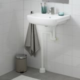 Moderní bílé umyvadlo BJÖRKÅN, chromová baterie, modrý držák, šedý ručník, stříbrný koš.