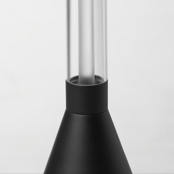 Moderní stojací lampa s elegantním, černým matným tělem a čirým válcovým stínidlem, která se vyznačuje vysoce kvalitním designem.