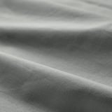 Detailní záběr měkkého bavlněného prostěradla se strukturou. Látka působí hladce a mírně pomačkaně, což zdůrazňuje její přirozenou, prodyšnou kvalitu.