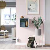 Minimalistický pokoj se světle růžovou skříní EKET, výzdobou, kaktusem a výhledem na město.