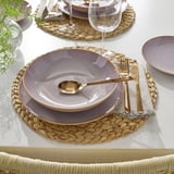 Elegantní prostírání s kameninovými talíři a příbory FÄRGKLAR, ideální k jídlu.