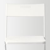 Skládací bílá židle, elegantní design, robustní ocelový rám, odolné plastové sedáky/opěradlo, ideální pro kompaktní prostory.