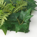 Panel z umělých rostlin se zářivě zelenými listy, připevněný k pevnému rámu, ideální pro domácí dekoraci.