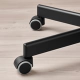 Černá kancelářská židle kolečka na světlé dřevěné podlaze. Kvalitní kolečka pro plynulý pohyb.