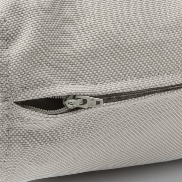 Detail zipu na povlaku polštáře z recyklovaného polyesteru. Viditelný detail kvalitního tahu zipu a prošívání.