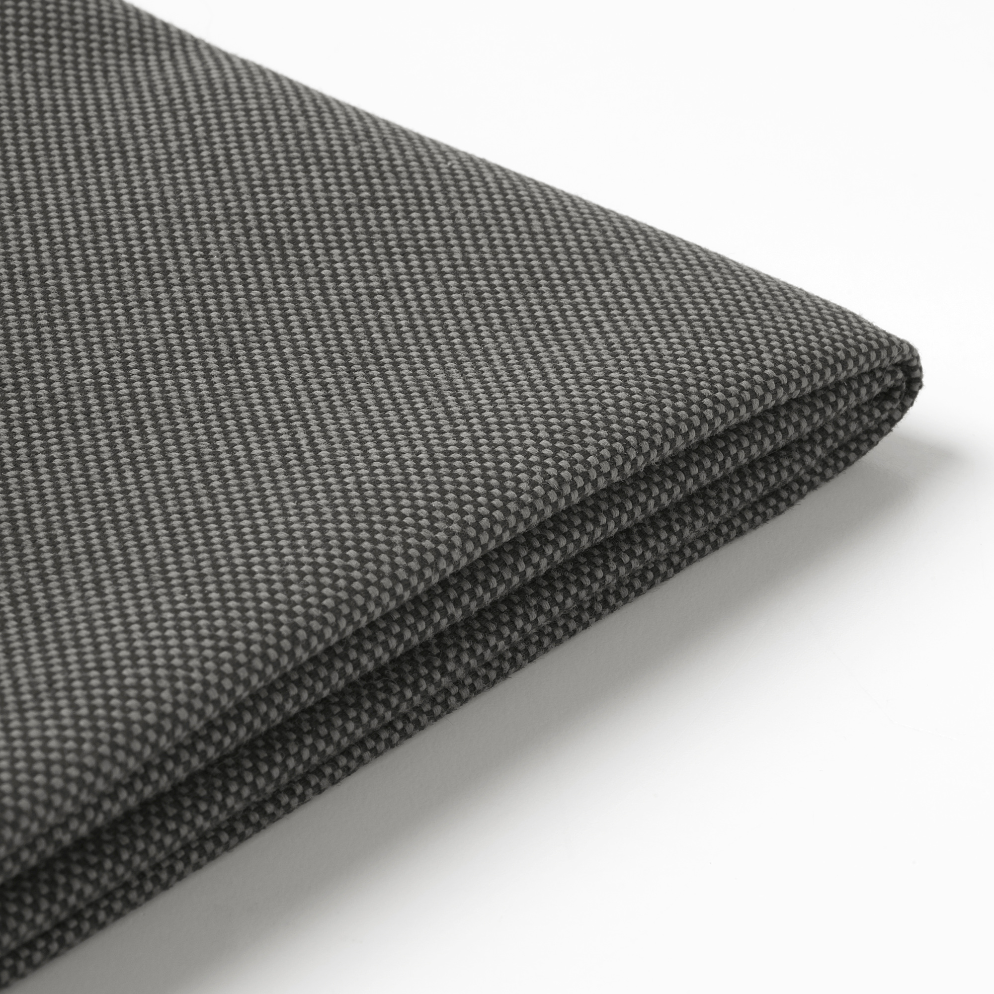 Detail tmavě šedé, texturované látky s jemným vzorem vazby. Zobrazuje detail přeloženého okraje a kvalitní materiál.