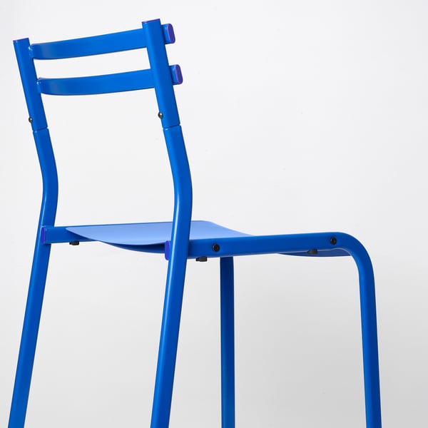 Jasně modrá kovová židle se šikmým opěradlem a sedákem. Robustní, moderní design.