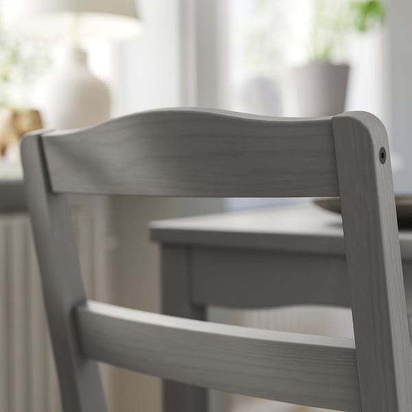 Tmavě šedá dřevěná židle zblízka, elegantní design se zakřiveným opěradlem.
