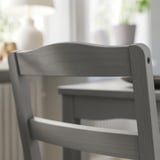 Tmavě šedá dřevěná židle zblízka, elegantní design se zakřiveným opěradlem.