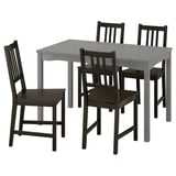 Šedý jídelní set HAUGA s obdélníkovým stolem a 4 černými židlemi, minimalistický design, ideální do malých prostor.