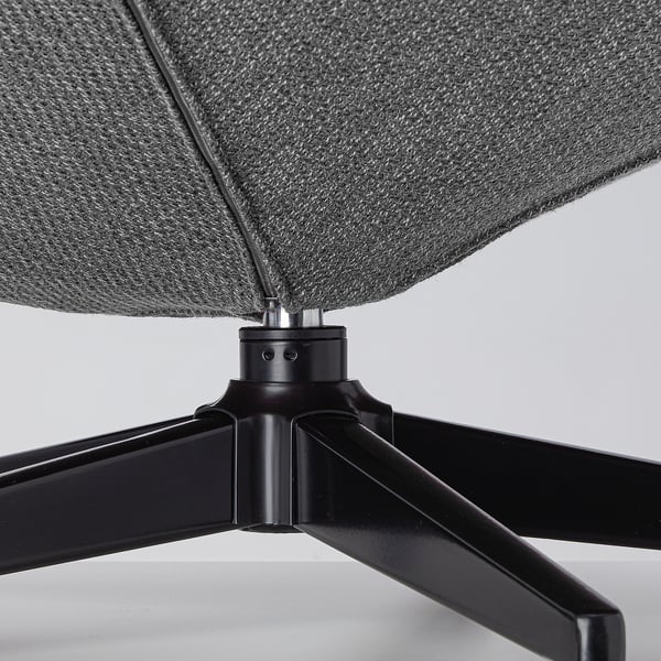 Moderní otočná základna židle, šedý látkový sedák, elegantní černé kovové nohy.