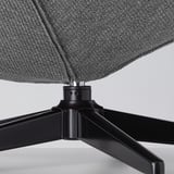 Moderní otočná základna židle, šedý látkový sedák, elegantní černé kovové nohy.