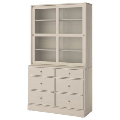 Béžový nábytkový díl HAVSTA se šesti zásuvkami a skleněnými dvířky, který kombinuje rustikální borovici a moderní design.