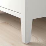 Elegantní konferenční stolek s elegantními, bílými nohami a skleněnou deskou. Moderní design, bytelná konstrukce.