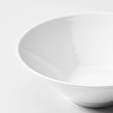 Čistý, bílý talíř s hladkým, lesklým povrchem a zaoblenými hranami. Kvalitní porcelán, odrážející světlo, sedící na rovném povrchu.