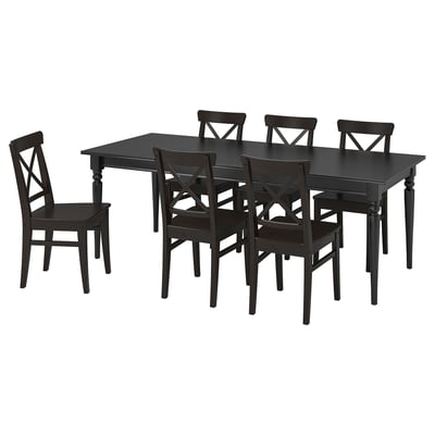 Černý obdélníkový jídelní stůl se šesti odpovídajícími židlemi. Jednoduchý, robustní design s dřevěnými židlemi s opěrkou X.