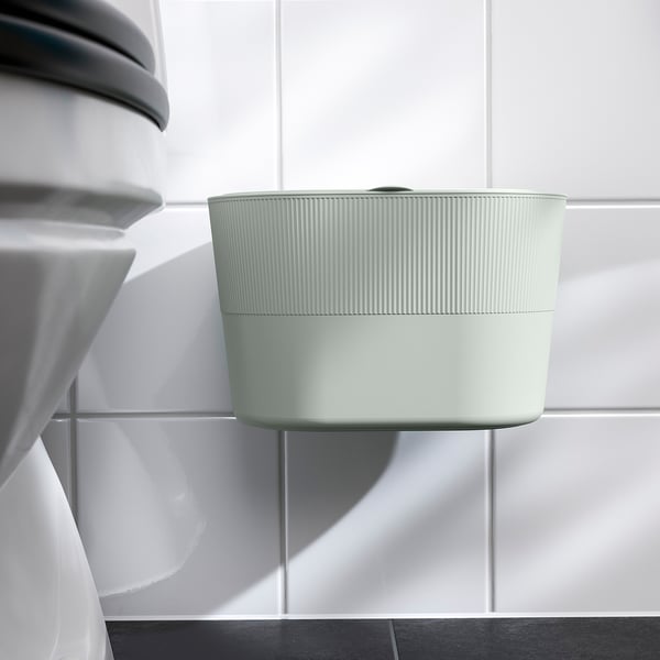 Moderní odpadkový koš s víkem, nástěnný, elegantní design. Visí na zeď pomocí lepicí pásky, udržuje prostor uklizený.